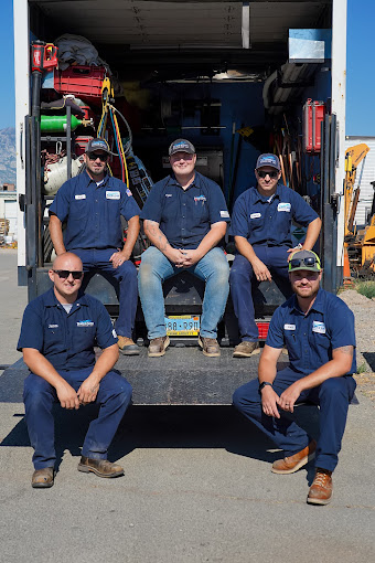 Beach & Sons team sitting in the back of a truck and facing the camera